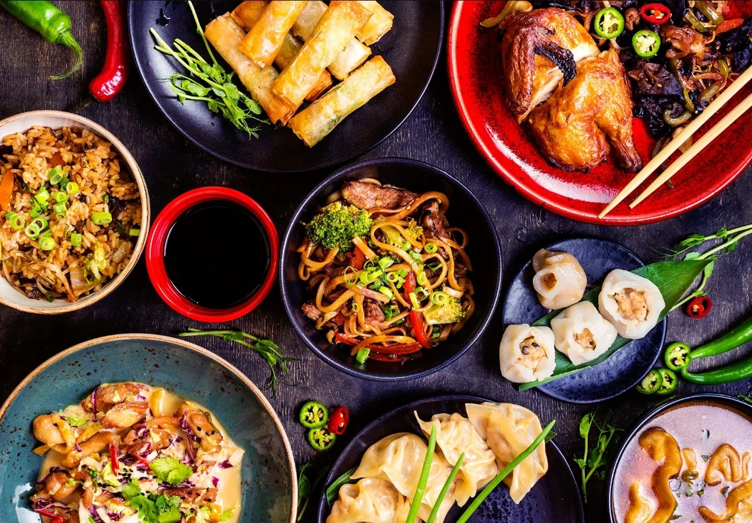 Assortiment de plats asiatiques avec riz, nouilles, nems et raviolis