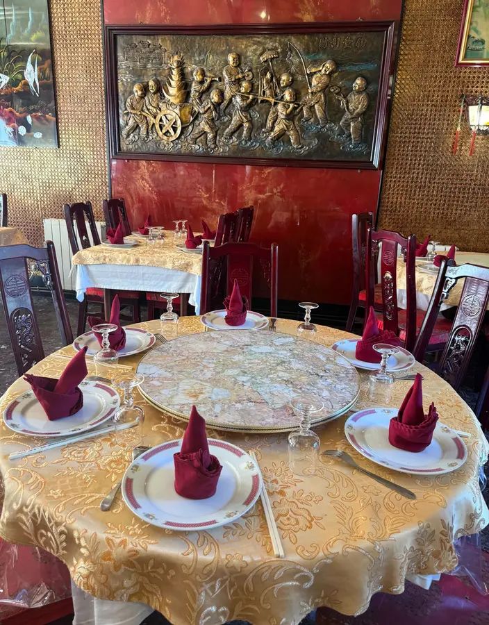 Table dressée devant un bas-relief décoratif au restaurant